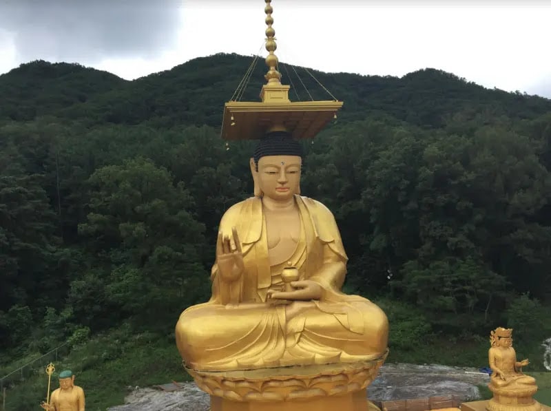 Large golden Buddha amid greenery in Seoul, South Korea