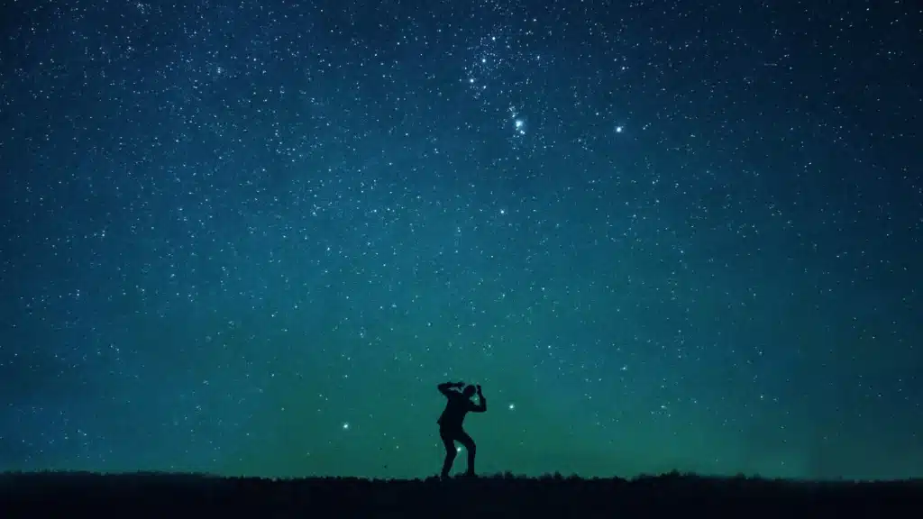 Shadow figure in a fearful pose under a starry sky