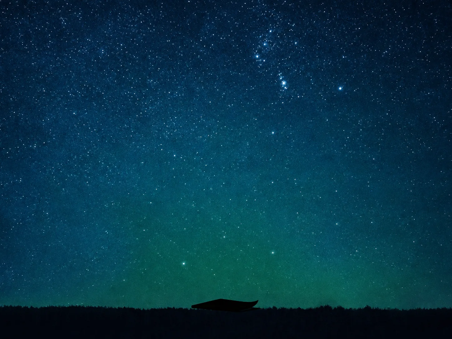 A folded sheet of paper in black silhouette beneath a star-filled sky